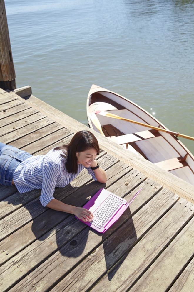 Woman works on a boat dock from an HP Stream 13" notebook.